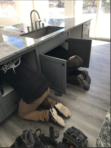 Electrician performing under-cabinet kitchen wiring