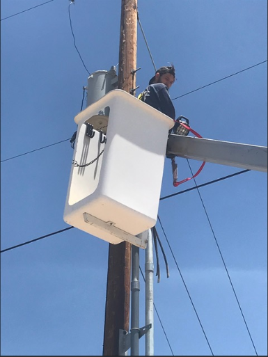 Electrician working on utility pole from bucket truck